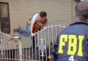 Un agent du FBI passe par dessus un portail